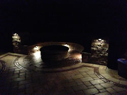 An outdoor fire pit surrounded by lighting