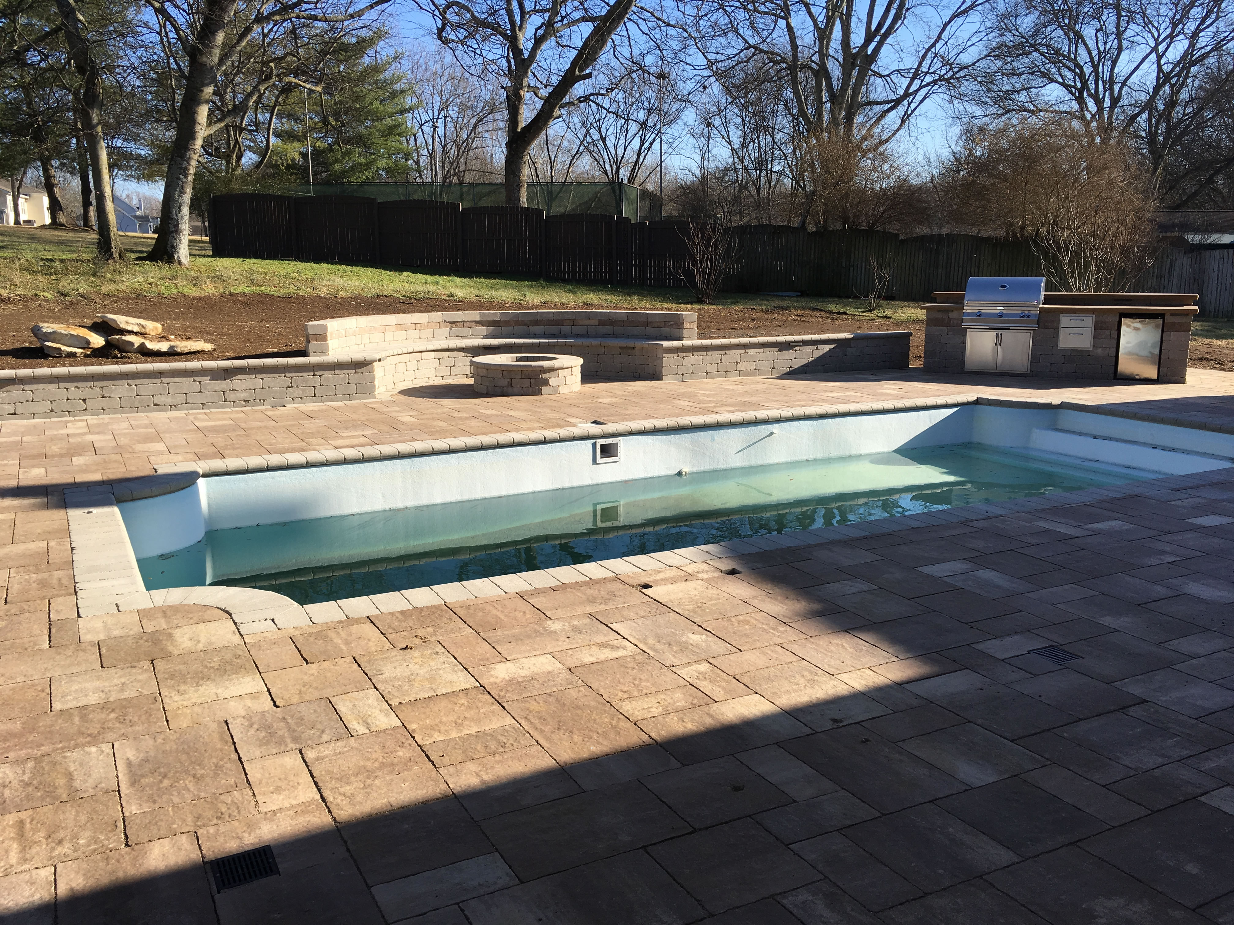 Paver patio, pool deck, outdoor firepit and seating walls and grill.